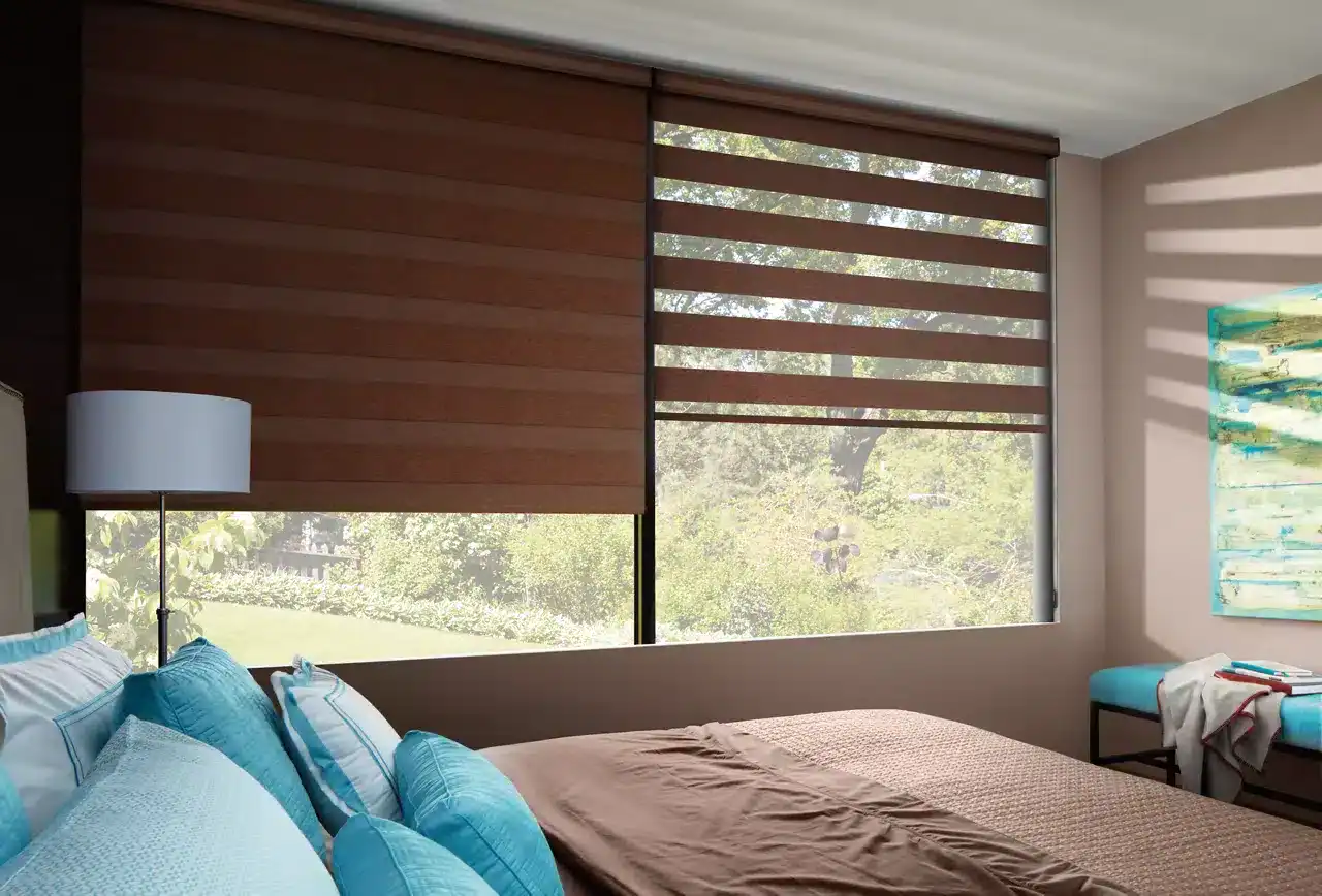 Bright hotel room with modern window blinds, blue bedding, and scenic outdoor view.