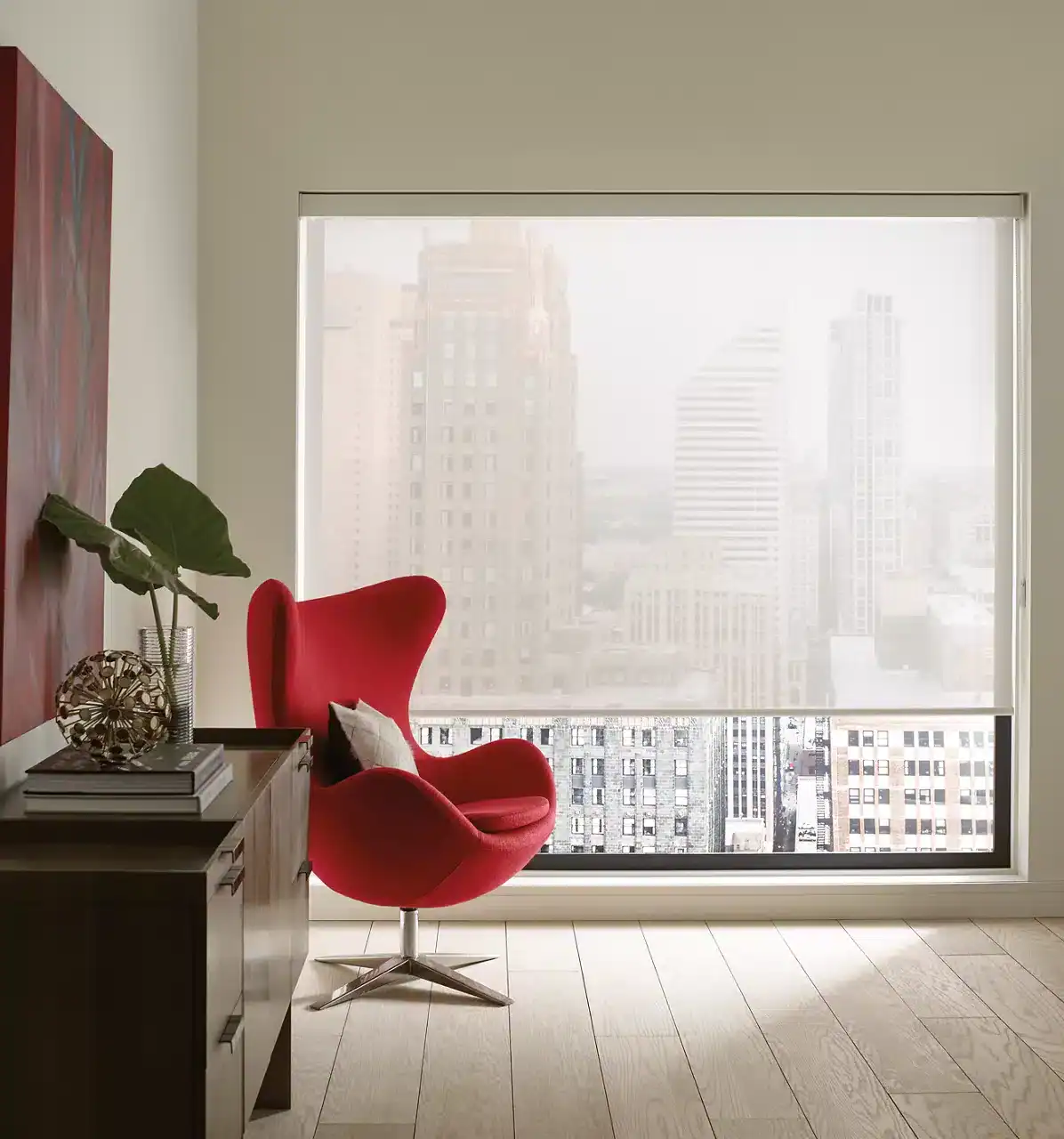 Stylish interior with a bright red lounge chair, modern decor, large balcony window, and city skyline background.