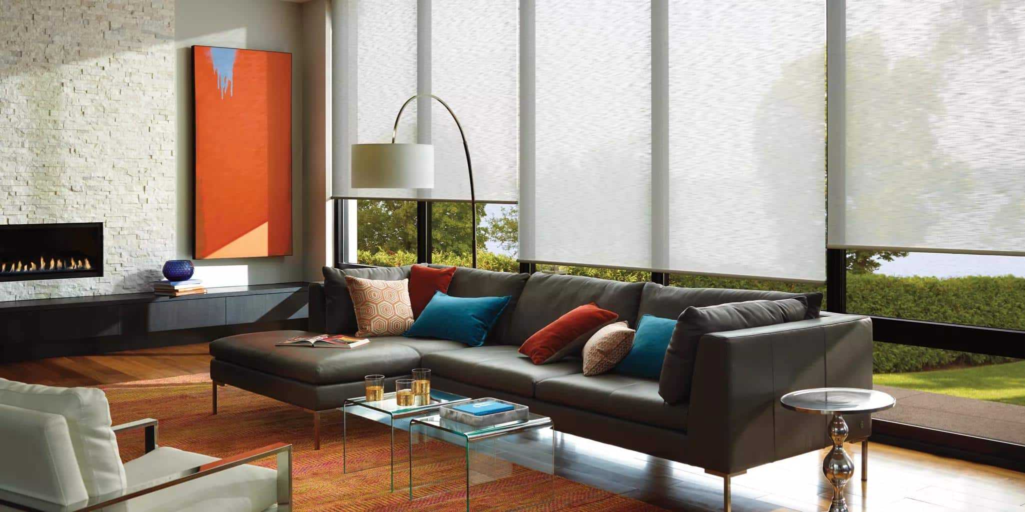 Bright, cozy interior with large windows, modern sofas, and decorative cushions in vibrant colors.