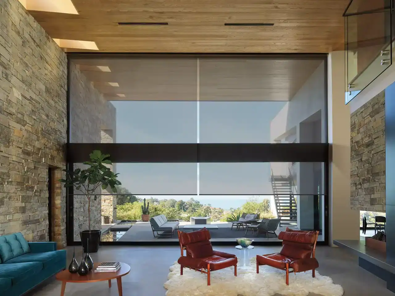 Bright, spacious modern living space featuring large glass windows, contemporary furniture, and a scenic outdoor view — perfect for relaxing and entertaining.