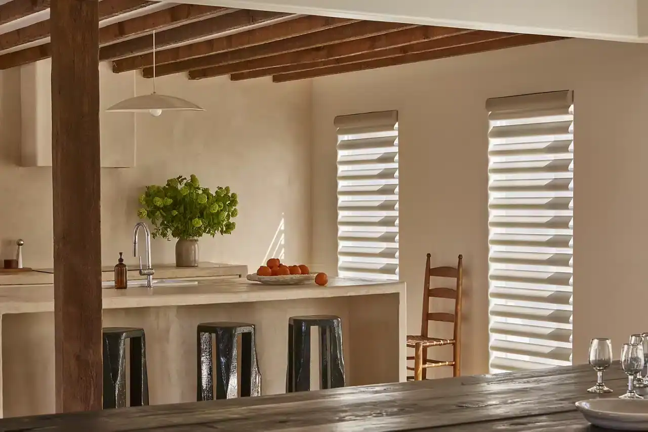 Bright and airy kitchen featuring white walls, wooden ceiling beams, and stylish window blinds. Perfect for contemporary home design.