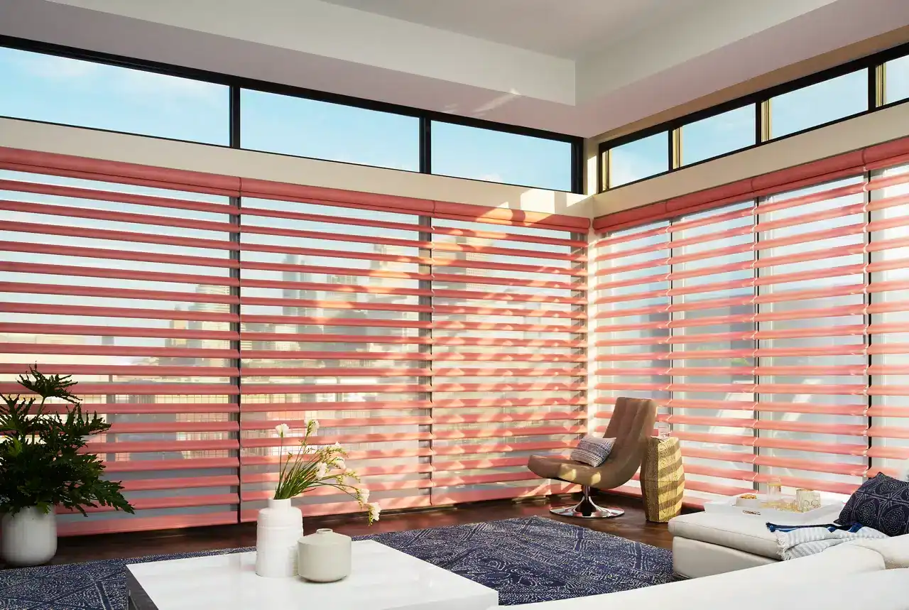 Bright living space with large windows and pink blinds, showcasing modern decor, comfortable seating, and cityscape exposure for a relaxed, contemporary atmosphere.