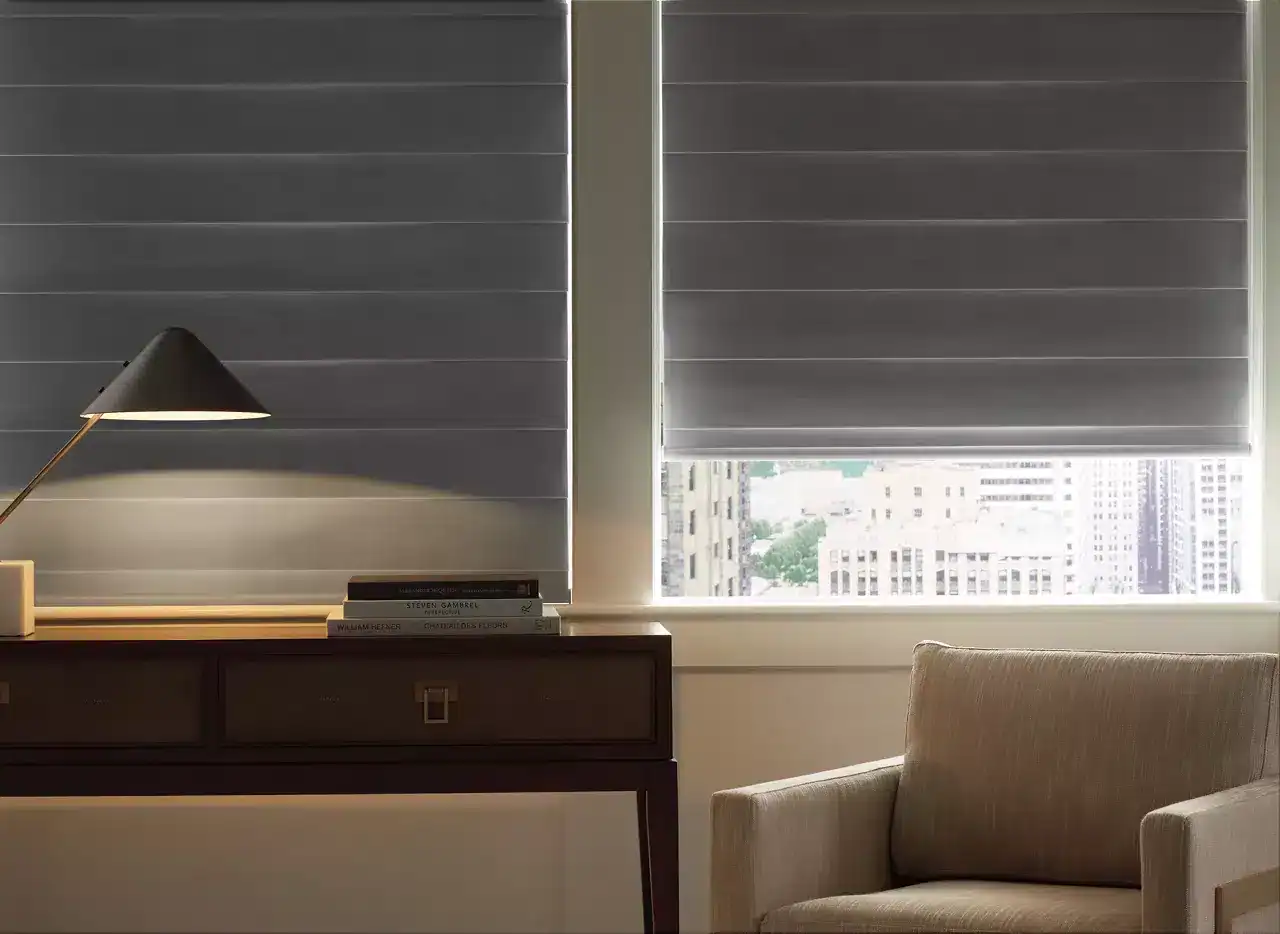 Stylish window blinds letting in natural light, modern furniture, comfortable armchair, home decor, urban view, relaxing interior, contemporary design, bright space, minimalistic style.