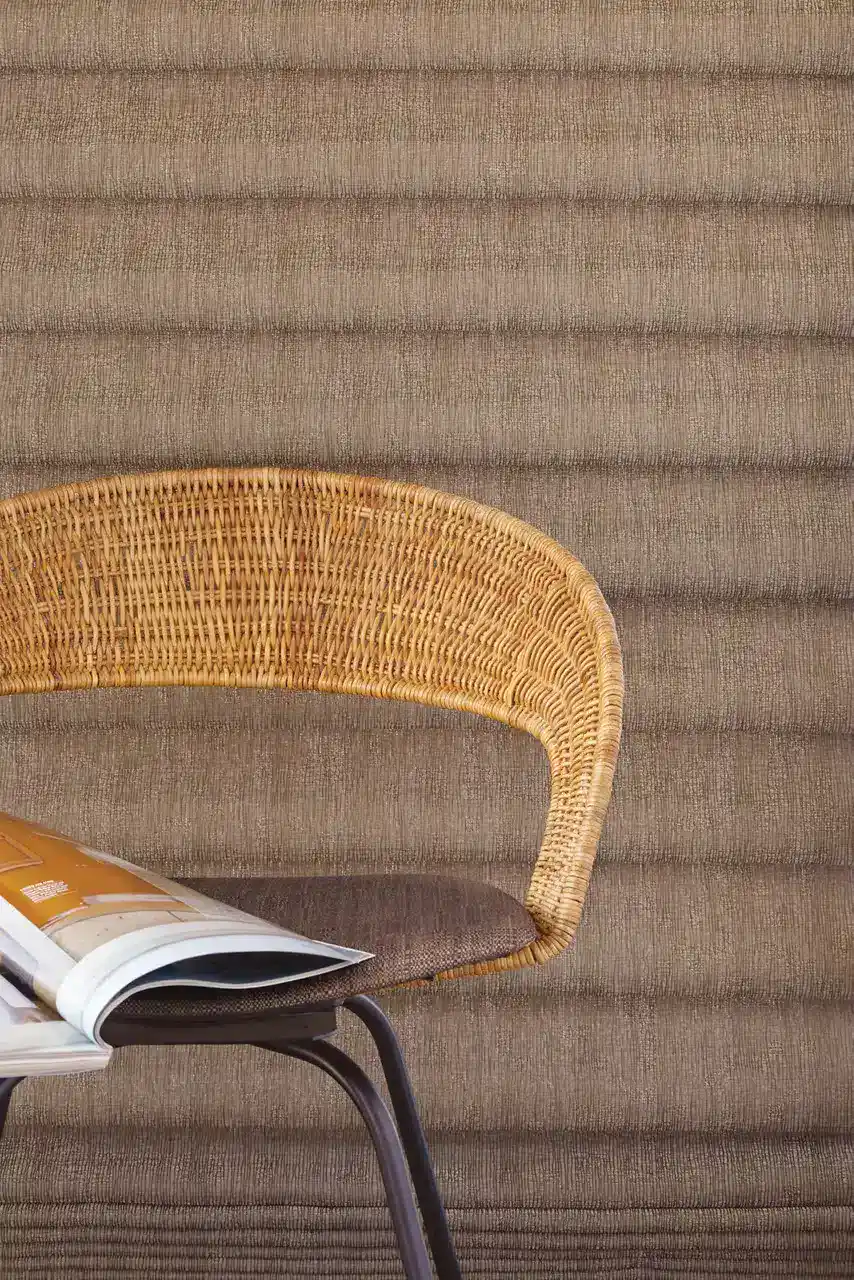 Comfortable wicker chair with curved backrest and cushions.