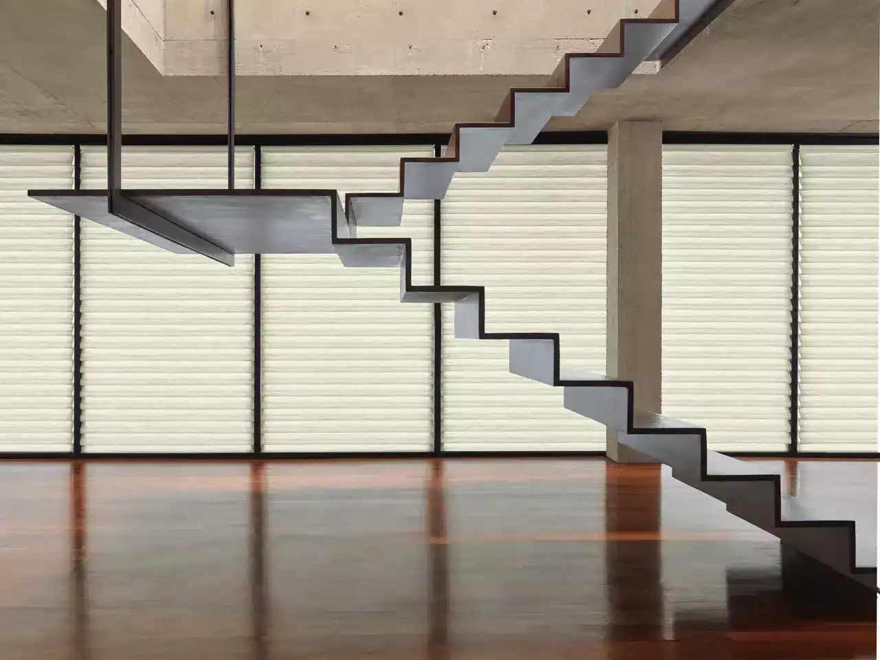 Staircase with minimalist black and white design against concrete wall and large windows, showcasing modern architecture and clean lines.