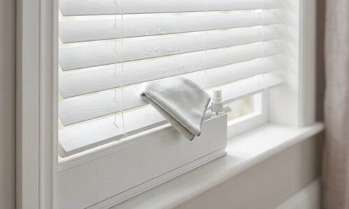 Bright white window blinds with a towel and cleaning spray on the window sill, ideal for maintaining a tidy and fresh home environment.