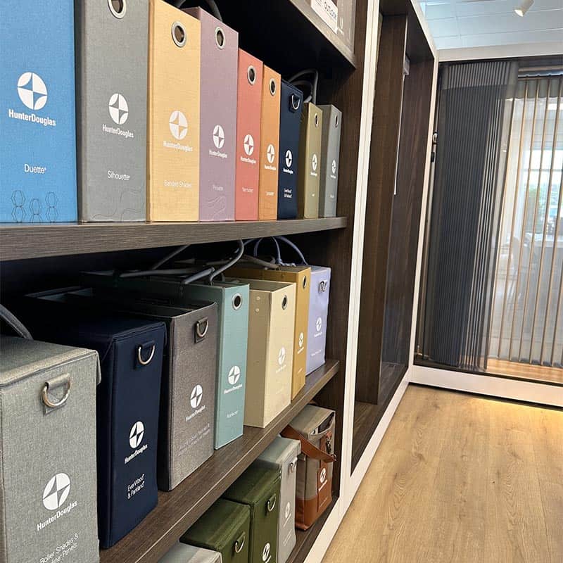 Brightly colored binders neatly arranged on wooden shelves in an office setting.
