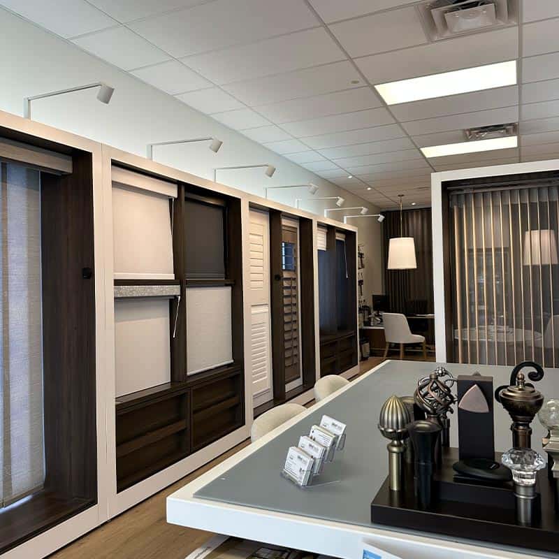 Elegant office space featuring dark wood display cabinets and a sleek meeting table with decorative items.