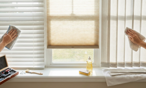 Cleaning window blinds with cloths in a bright room, maintaining cleanliness and hygiene.