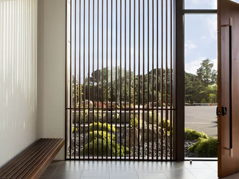 Modern interior with vertical aluminium louvers filtering daylight Modern interior with vertical aluminium louvers filtering daylight