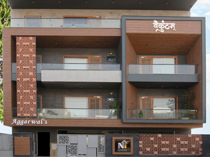 Modern multi-storey building façade with wood-look ACP perforated panels and contemporary balcony design