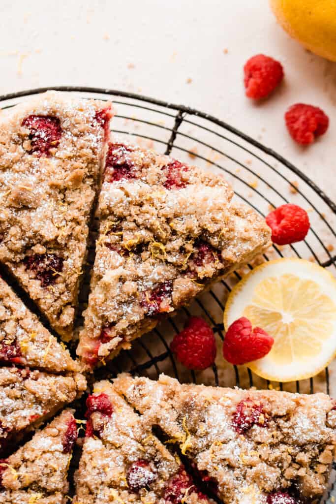 Sliced wedges of the raspberry coffee cake with raspberries scattered around.