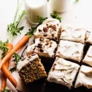 The carrot cake frosted and sliced, with crushed pecans on top.