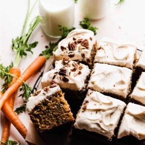 The carrot cake frosted and sliced, with crushed pecans on top.