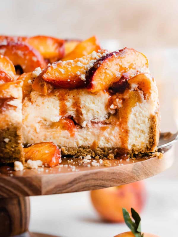 This Peach Cobbler Cheesecake has a layer of juicy peaches and cinnamon streusel baked in the center of an ultra creamy vanilla cheesecake. Top the cheesecake with more peaches and streusel for a showstopper summer dessert!