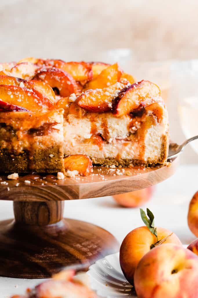 A straight-on view of the inside of the cheesecake, which is topped with juicy peaches and cinnamon streusel.