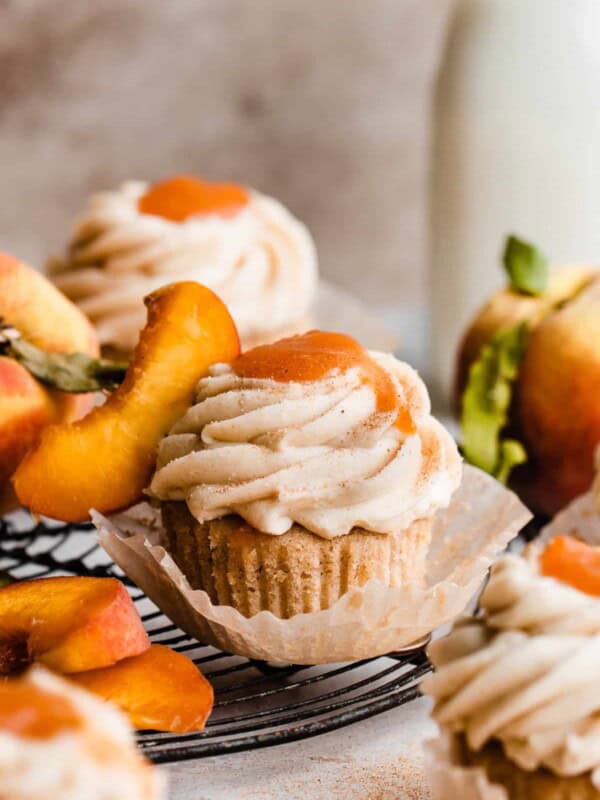 Peach cupcakes topped with frosting and peach filling.