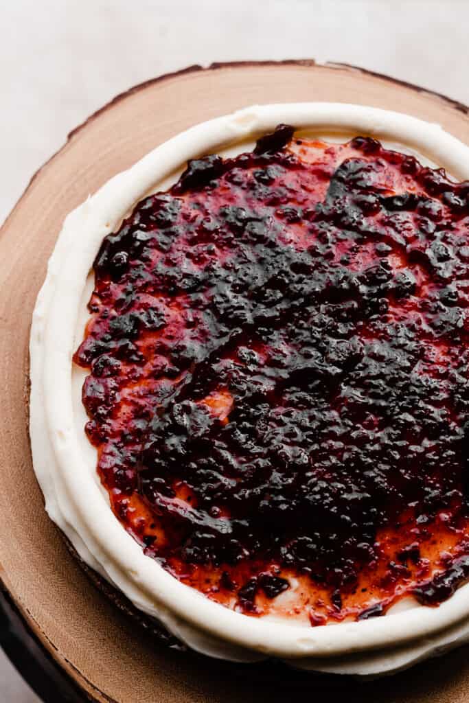 A layer of cake frosted, with a border piped containing a layer of cranberry jam.
