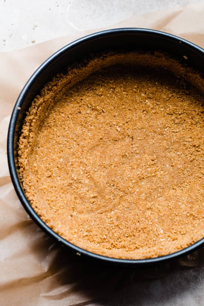 Graham cracker crust in a springform pan.