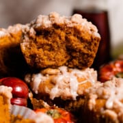 A close-up on a stack of muffins with one broken open, showing the fluffy moist insides.