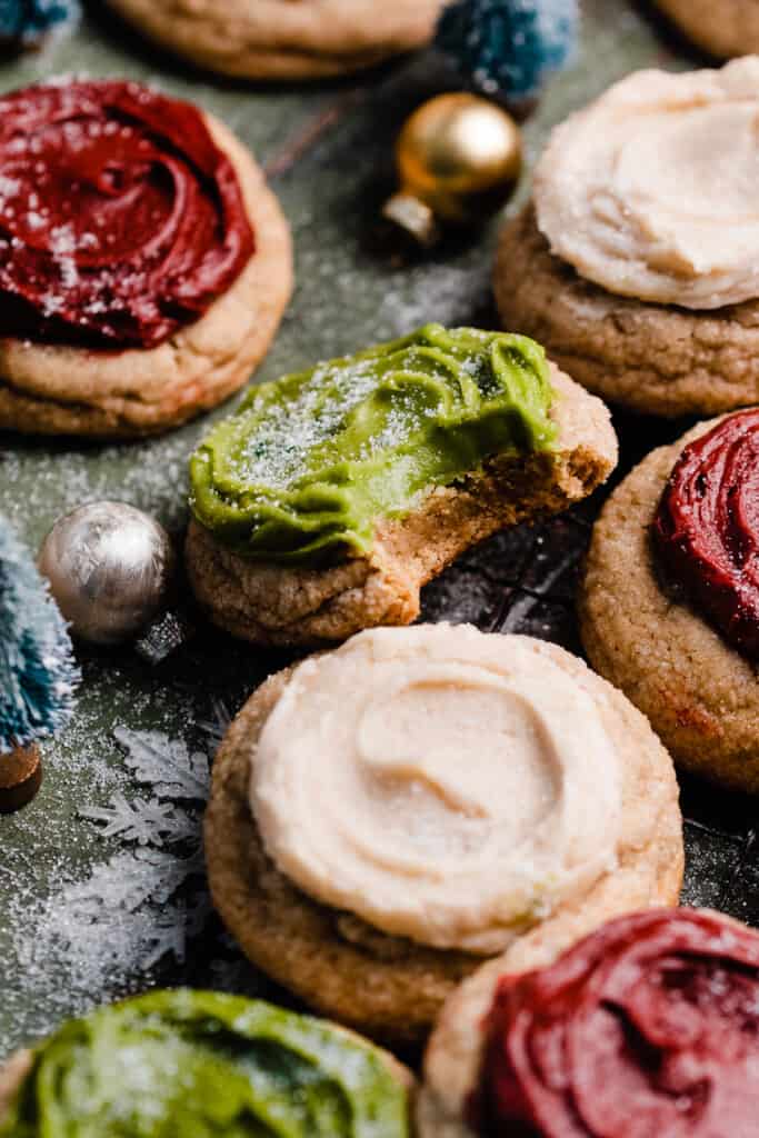 A close-up of a frosted cookie with a bite missing.