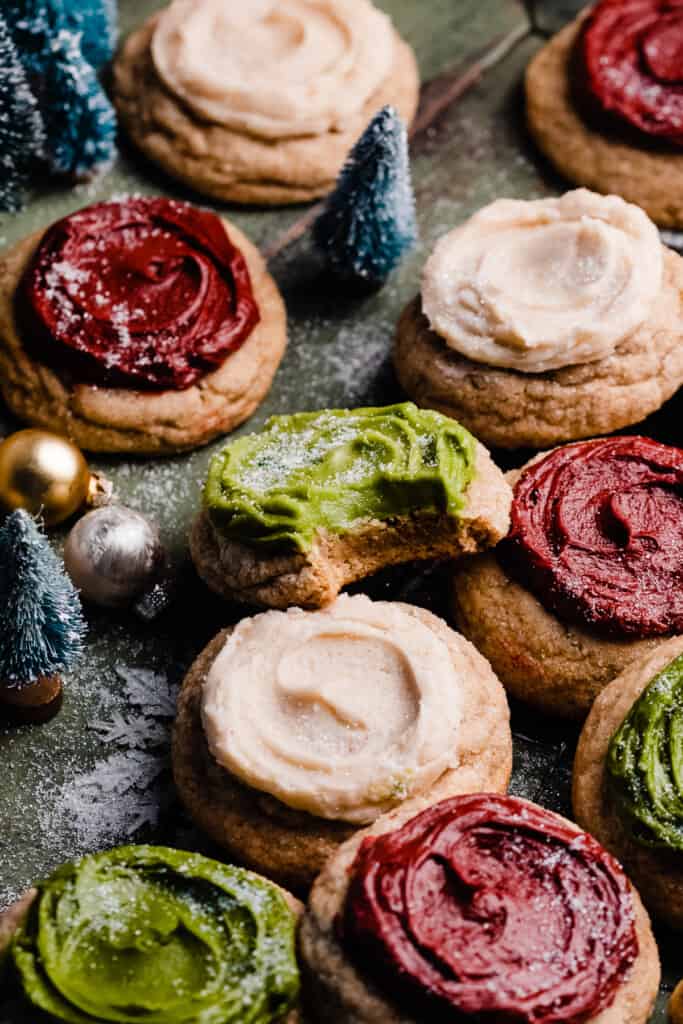 Frosted sour cream cookies on a wire rack, frosted in red, white, and green colors.