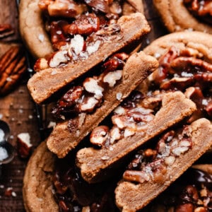 The halves of four pecan pie cookies, stacked, to show the chewy insides and pecan pie filling.