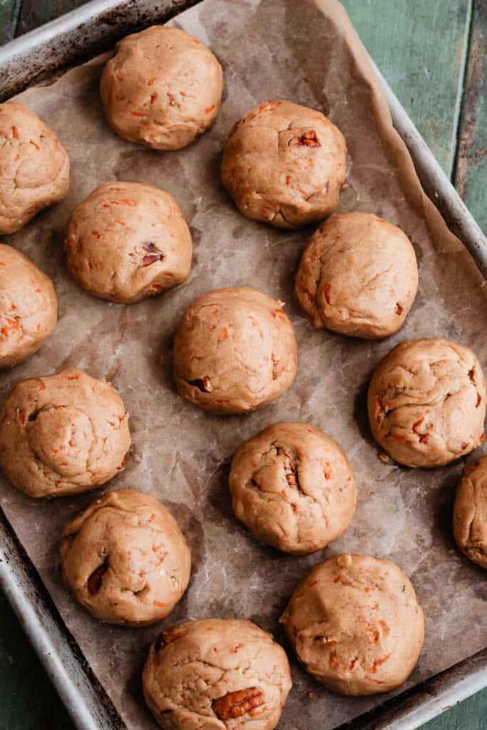 Cookie dough balls chilling on a sheet pan.