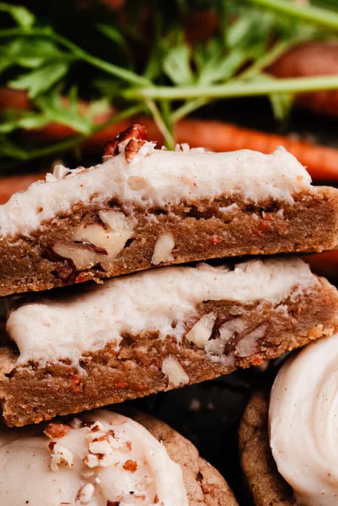 A close-up of two halves of carrot cake cookie, showing the chewy texture inside.
