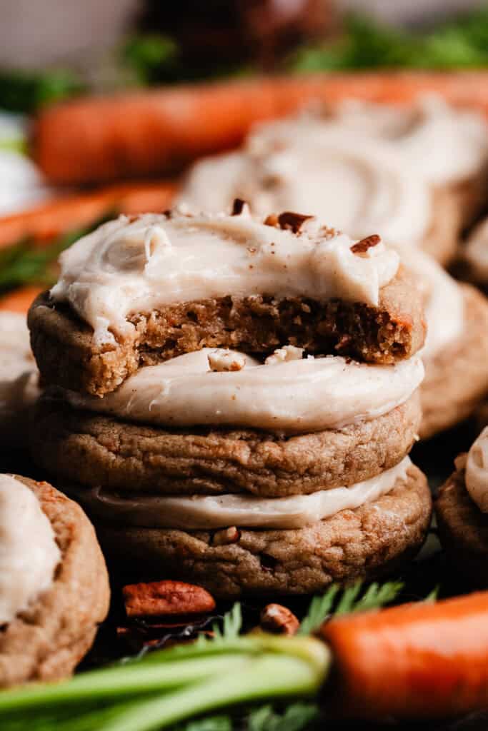 A stack of frosted carrot cake cookies.