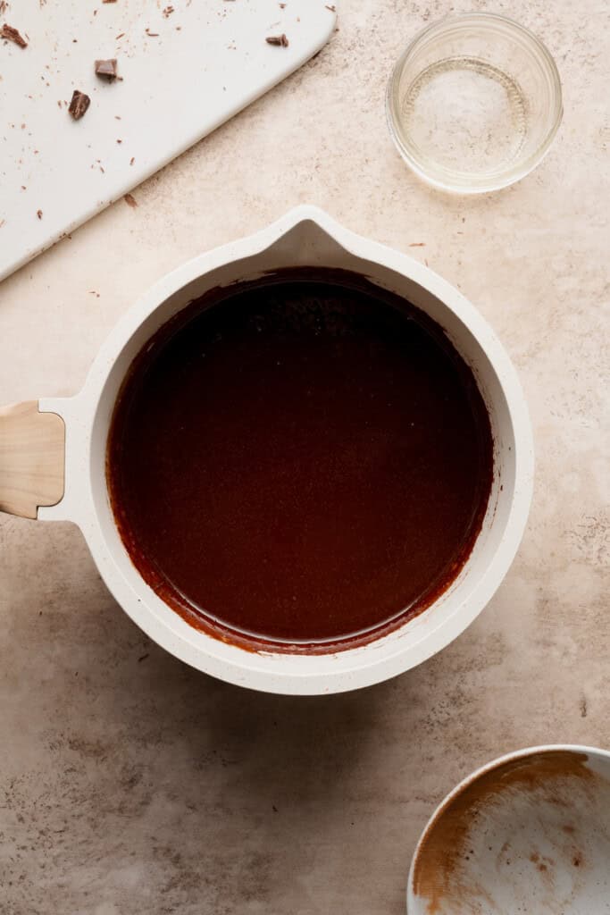 A small saucepan with the melted chocolate, butter, cocoa, and oil mixed together.