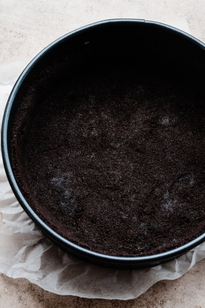 The crust mixture pressed into a 9-inch springform pan, ready to be baked and filled.