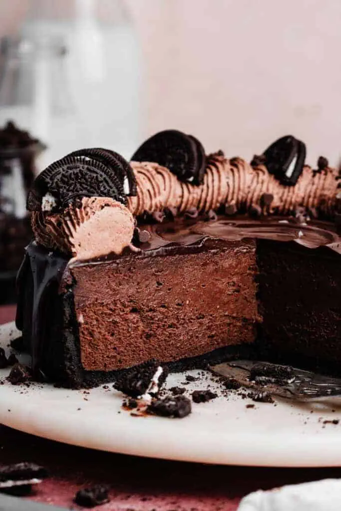 A close-up on the sliced triple chocolate cheesecake on a cake plate.