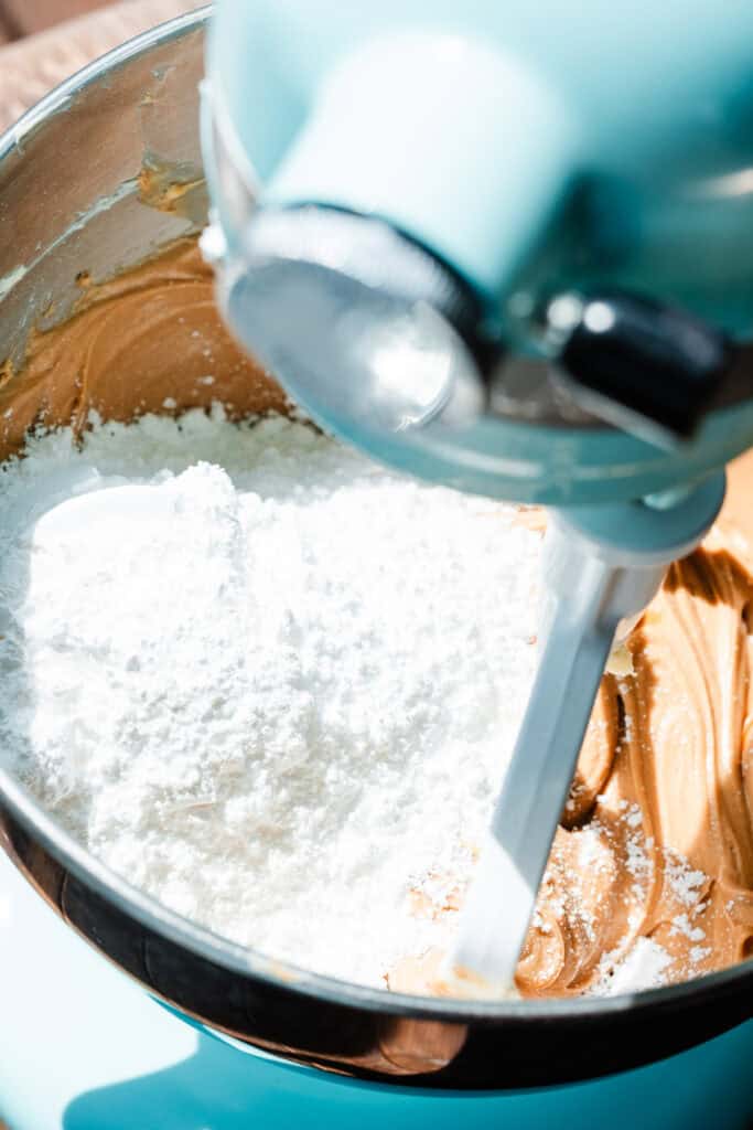 Powdered sugar being added to the peanut butter mixture.