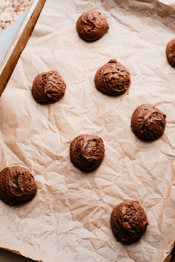 A baking sheet with dollops of the chocolate batter, ready to be baked.