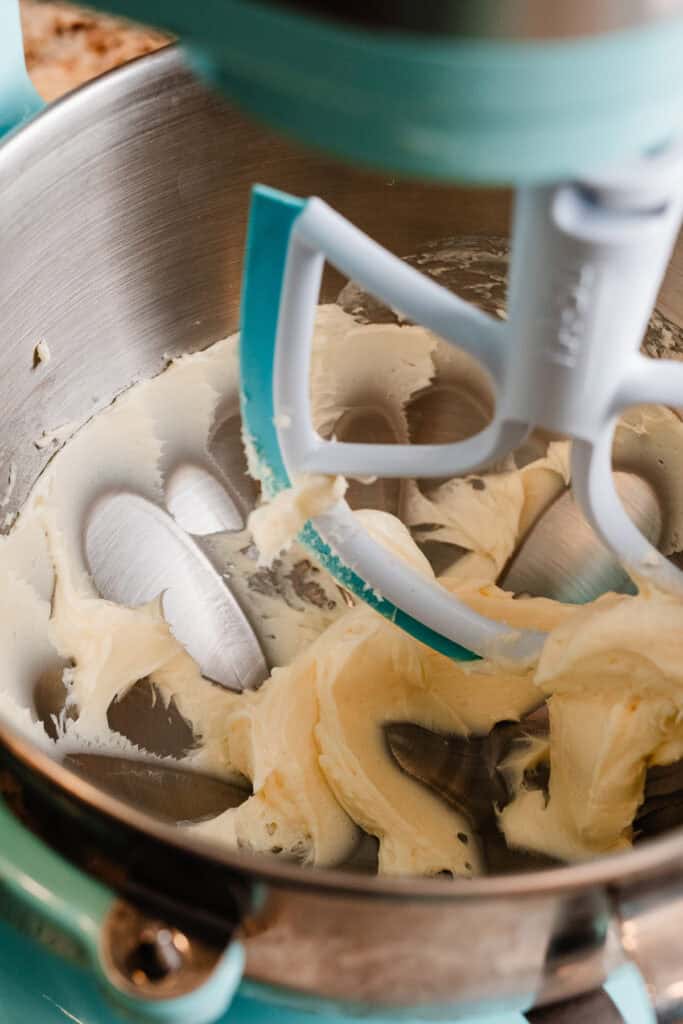 A stand mixer bowl filled with creamed butter.