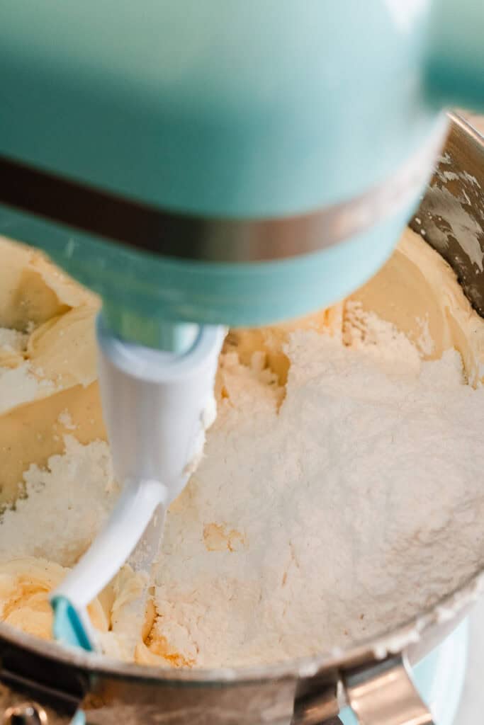 Powdered sugar added to the bowl of butter and cream cheese.