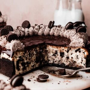 The sliced oreo cheesecake on a marble cake plate, showing the creamy texture and oreo pieces inside.