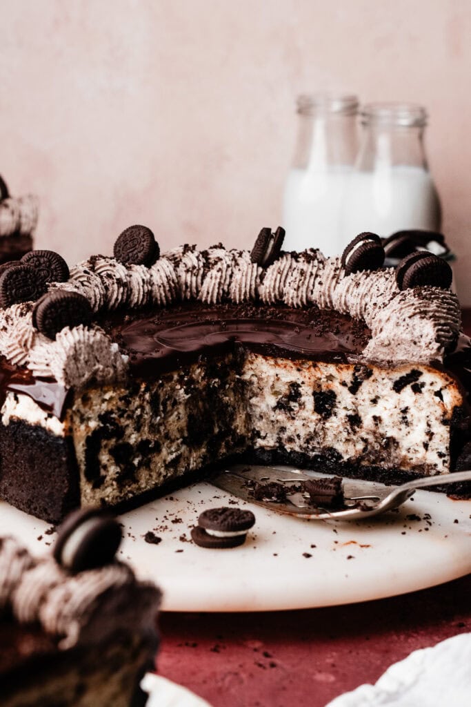 A photo of the sliced cheesecake on a marble cake plate, showing the creamy texture and oreo pieces inside.