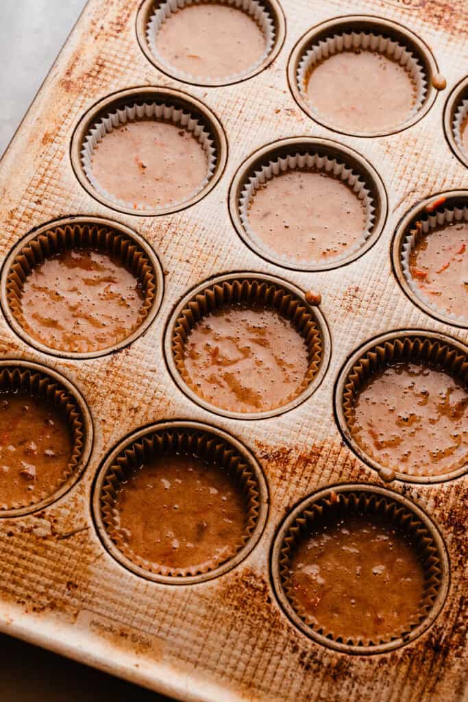 A cupcake pan full of batter, ready to be baked.