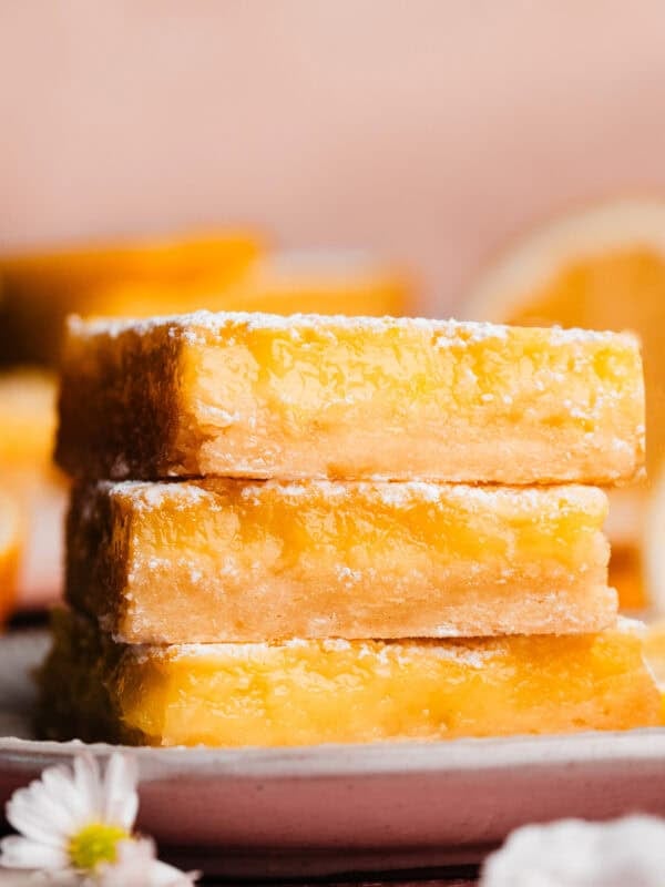A stack of three luscious lemon bars on a plate.