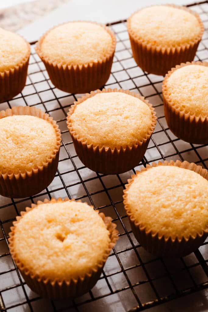 Baked cupcakes cooling on a cooling rack.
