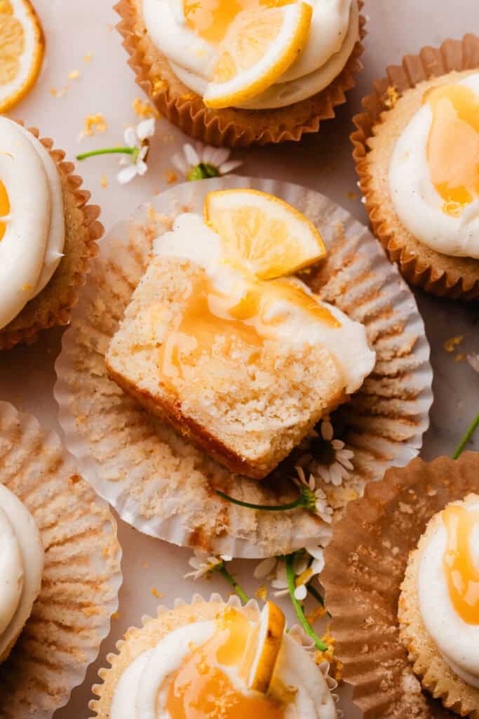 A bird's eye view of half a lemon cupcake. The inside fluffy texture is visible, along with the lemon curd filling.