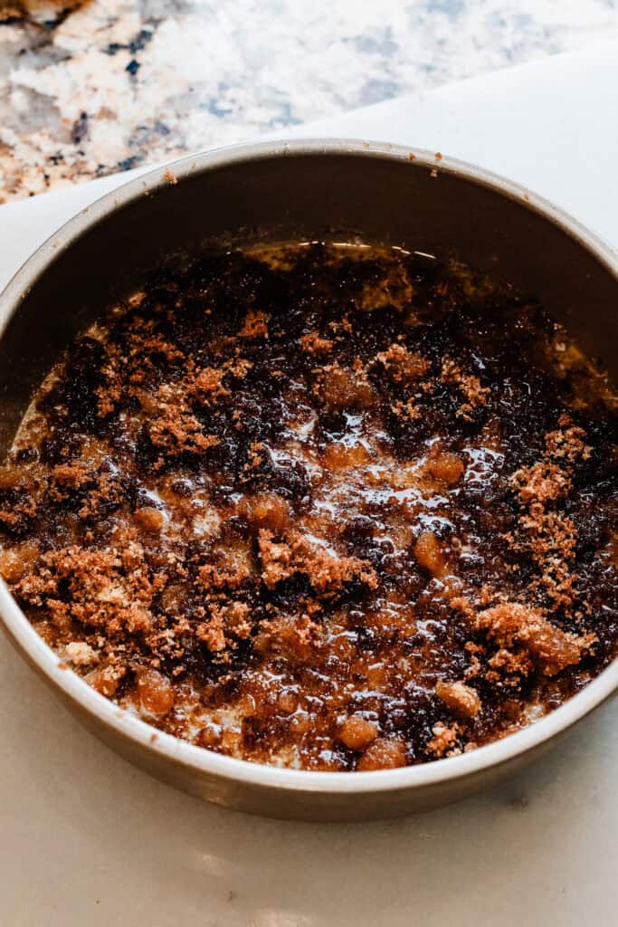 Melted butter layered with brown sugar in the bottom of a cake pan.