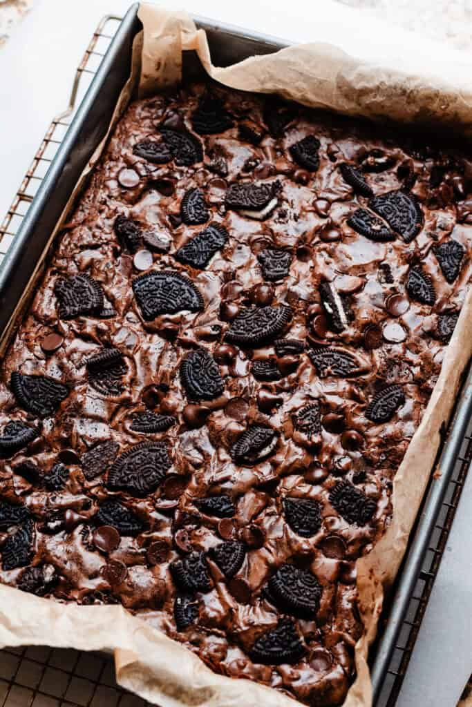 A pan of the baked oreo brownies, cooling on a wire rack.