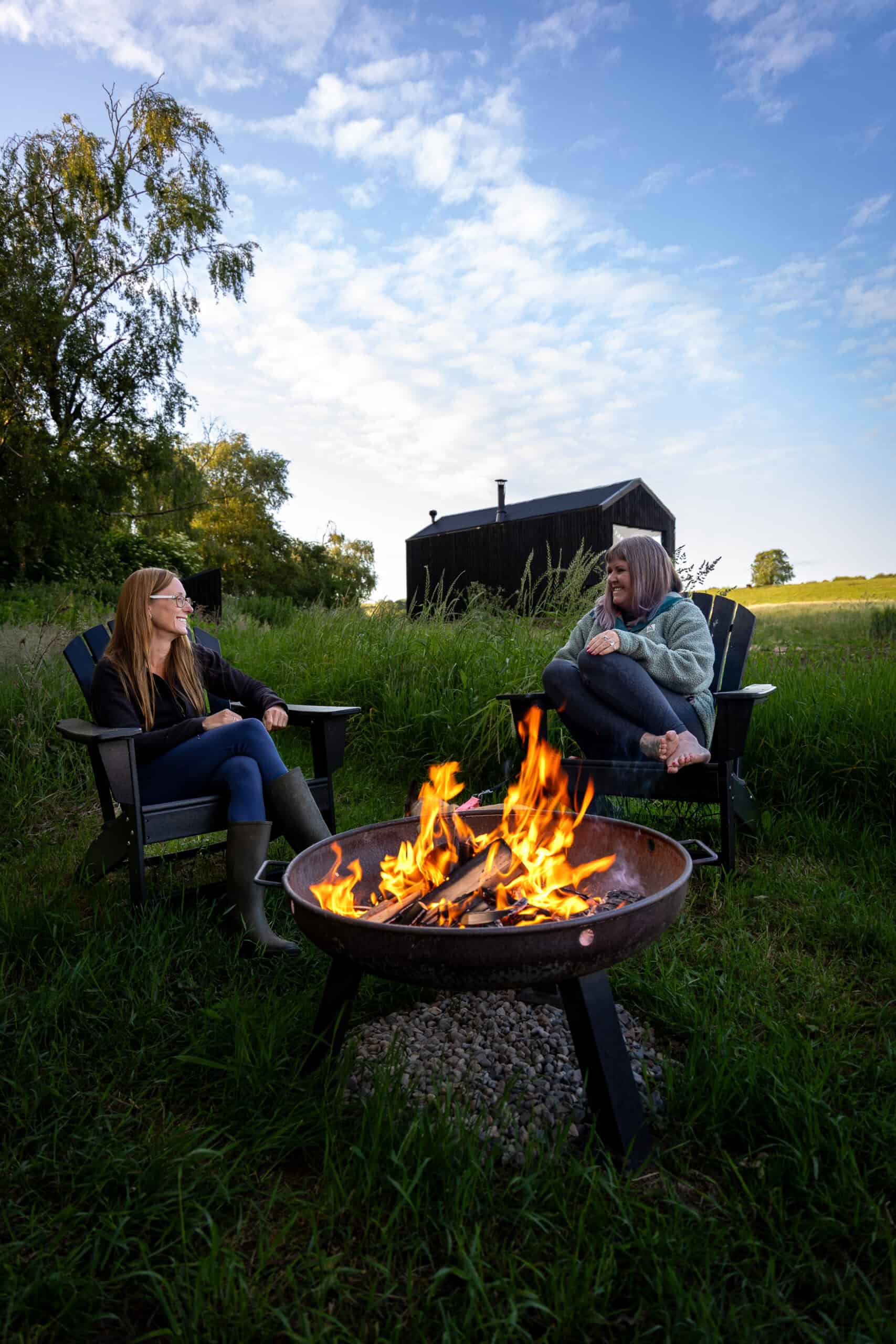 Secluded off grid glamping site with cozy campfire and outdoor seating, perfect for sustainable living and rural escape.