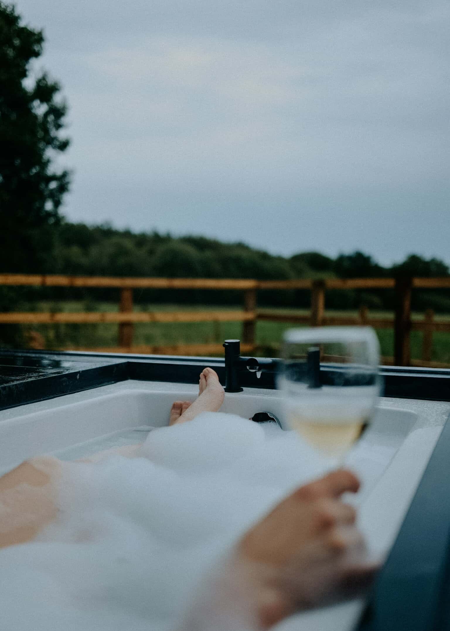 Relaxing off-grid experience with hot tub and wine, enjoying nature and eco-friendly living at Live Off Grid. Perfect for sustainable getaways and disconnecting from everyday stress.