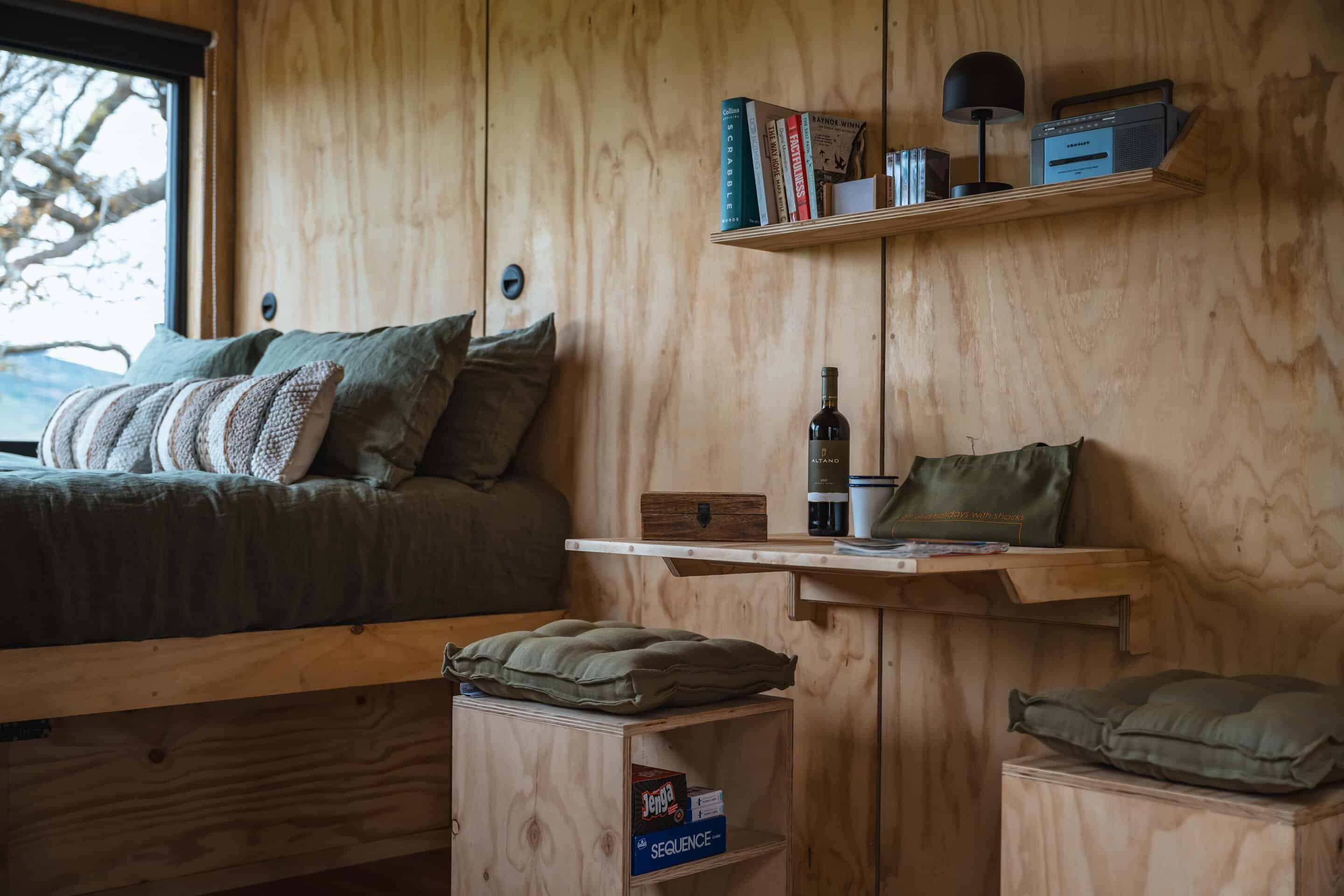 Cozy off-grid tiny home interior with wooden walls, comfortable seating, and minimalist decor, perfect for sustainable living and enjoying the benefits of staying off grid in nature.
