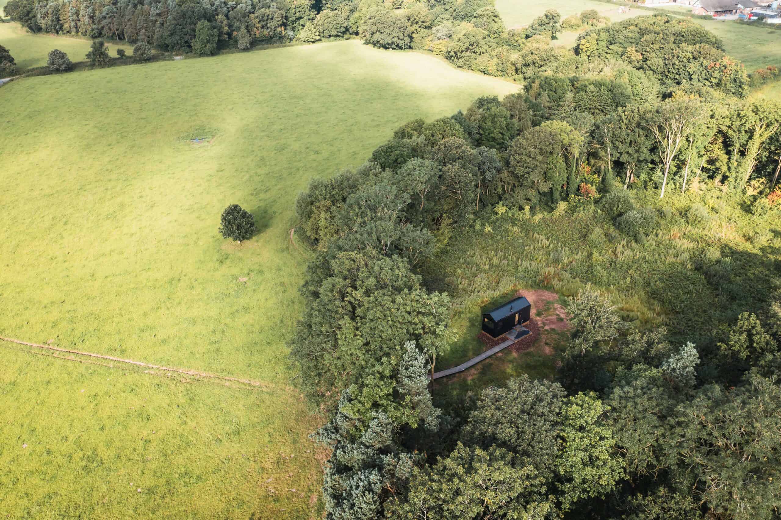 Secluded off-grid tiny house surrounded by lush trees and greenery, perfect for sustainable living and disconnecting from modern life. Ideal for eco-friendly outdoor adventures.
