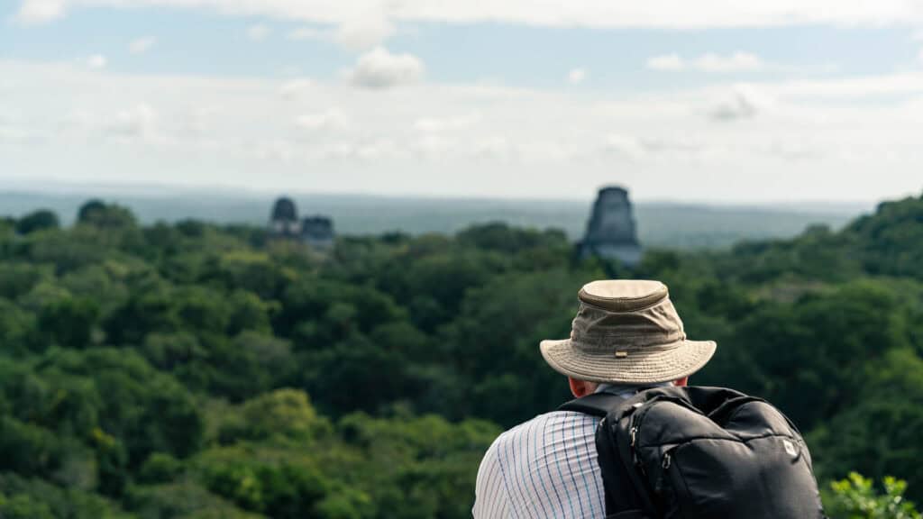 A tourist looking out over the temples of Tikal Guatemala